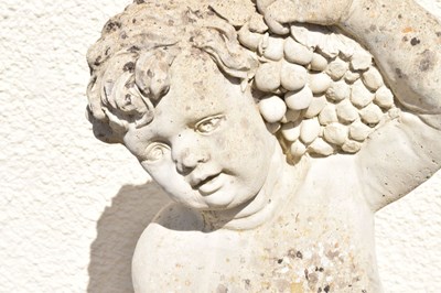 Lot 795 - Composite stone garden statue of a cherub holding grapes