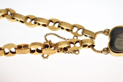 Lot 48 - Victorian unmarked gold engraved mariner link bracelet with garnet carbuncle heart locket