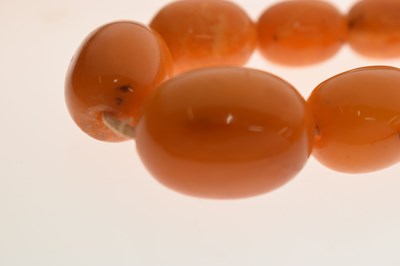 Lot 37 - String of graduated oval butterscotch amber beads
