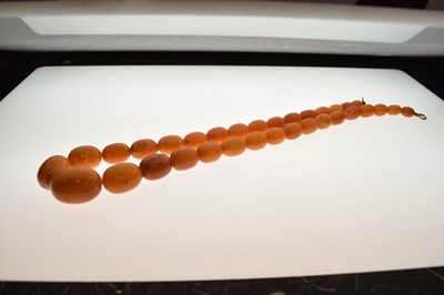 Lot 37 - String of graduated oval butterscotch amber beads