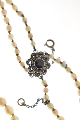 Lot 43 - Edwardian graduated pearl double string necklace with sapphire set clasp