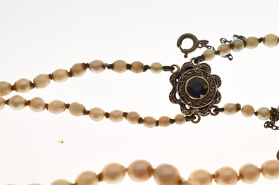 Lot 43 - Edwardian graduated pearl double string necklace with sapphire set clasp